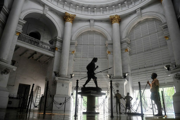 A sweeper cleans the floor of the General Post Office in Kolkata after some lockdown restrictions were relaxed