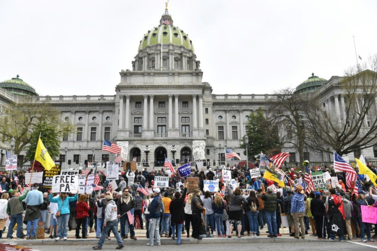 The incessant clang of horns rang out in Harrisburg, Pennsylvania as hundreds of vehicles -- often pick-up trucks decorated with American flags or slogans like "shelter in place isn't freedom!" -- circled the capitol building