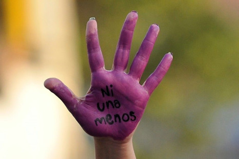 An activist displays her hand reading "Not One Less" during a march to mark the International Day for the Elimination of Violence Against Women in Naucalpan, Mexico
