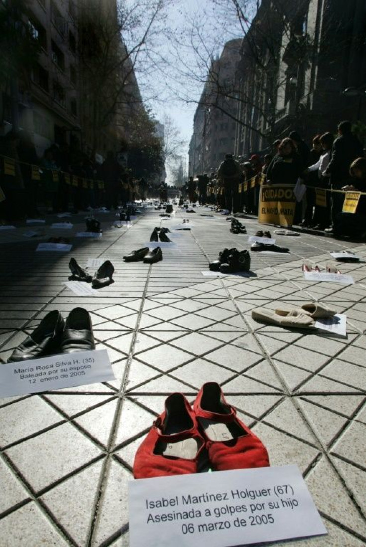 A sign next to a pair of shoes reads "Isabel Martinez Holguer (67), beaten to death by her son on March 6th, 2005" during a demonstration organized by the Chilean Network Against Domestic and Sexual Violence in Santiago