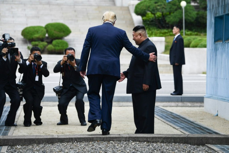 US President Donald Trump steps into the northern side of the Military Demarcation Line that divides North and South Korea as North Korea's leader Kim Jong Un looks on in June 2019