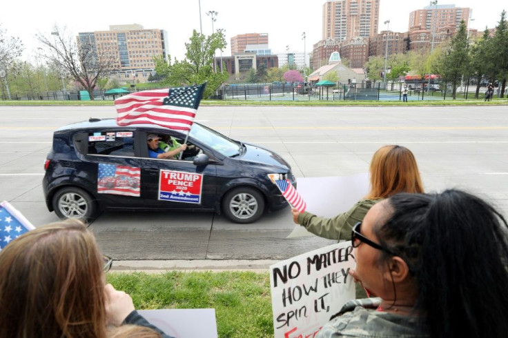A supporter of President Donald Trump in Kansas City, Missouri waves an American flag during a protest against restrictions imposed on businesses to fight the COVID-19 pandemic