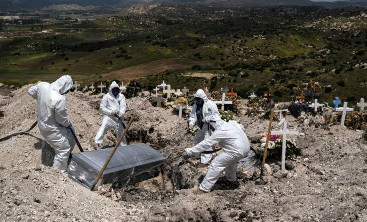 Cementery workers wearing protective gear bury an unclaimed COVID-19 victim, at the Municipal cementery No. 13 in Tijuana, Baja California state, Mexico