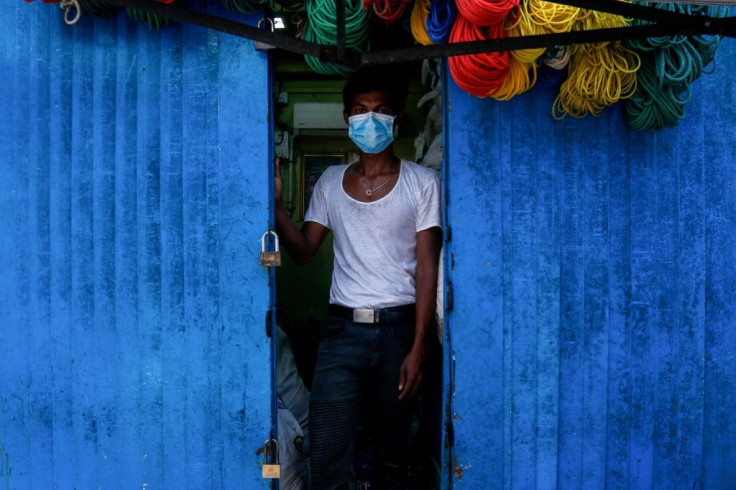 A man stands at the entrance to his shop in downtown Yangon, Myanmar