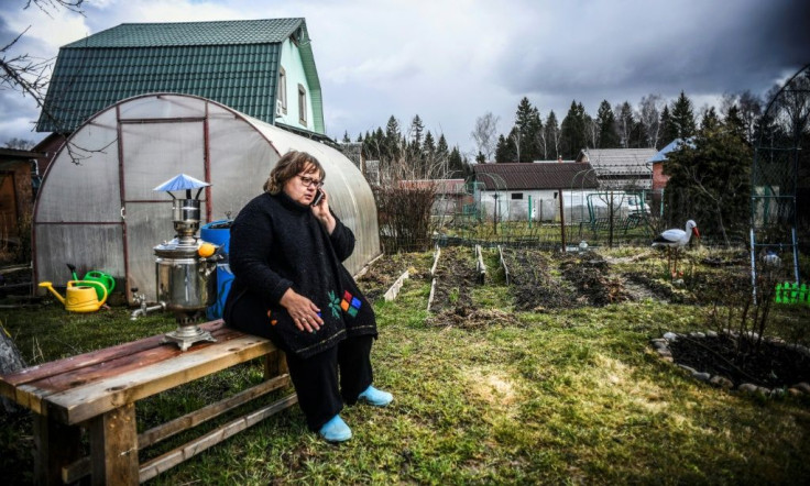 Nataliya Sapiga, a 53-year-old school teacher, talks on the phone in a yard of her dacha