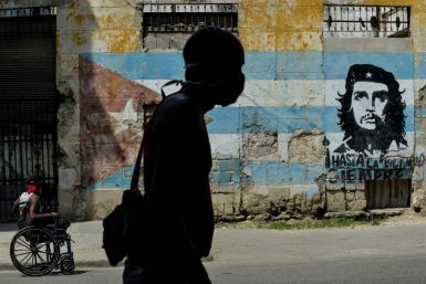 A Cuban man wears a face mask in front of a mural showing revolutionary Che Guevara in Havana -- the coronavirus cases are limited here, but food shortages have become worse as a result of the crisis