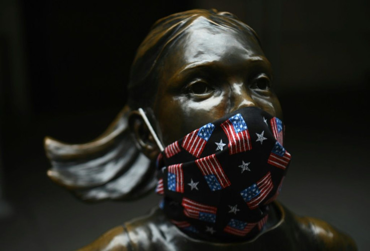 The "Fearless Girl" statue wears a face mask with American Flags outside the New York Stock Exchange on Wall Street