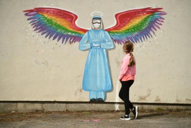 A girl looks at a mural by artist Rachel List paying tribute to NHS staff in Britain