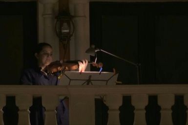 Members of Qatar's philharmonic orchestra perform from their balconies one last time before Ramadan in Qatar's Qanat Quartier, a part of Doha's man-made Pearl island