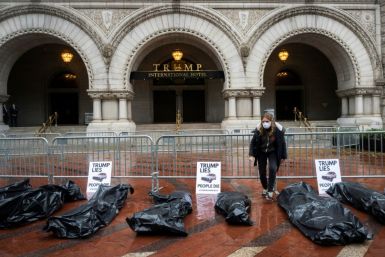 Participants in a "People's Motorcade" stop at the Trump International Hotel to deliver fake body bags during a protest against the administration's response to the COVID-19 pandemic in Washington, DC