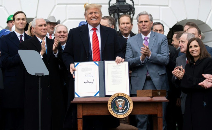 US President Donald Trump holds up the signed United States- Mexico-Canada Trade Agreement, known as USMCA, during a White House ceremony in January 2020