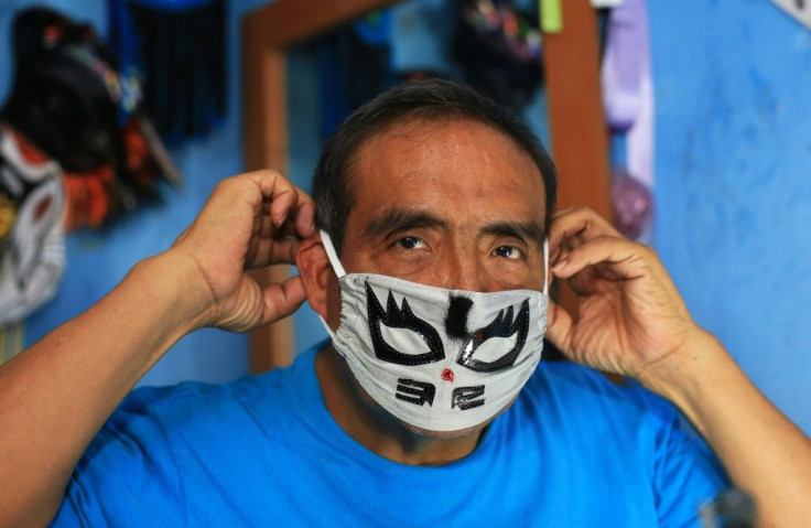 Jose Isaias Huerta tries on one of the masks he manufactured in Puebla, Mexico