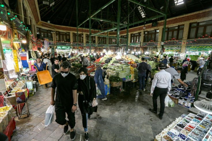 Shoppers clad in protective gear, including face masks and latex gloves, walk through Tajrish Bazaar in Iran's capital Tehran at the start of the Muslim holy month of Ramadan