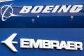 This combination of file pictures created on December 21, 2017 shows the Boeing logo on the fuselage of a Boeing 787-10 Dreamliner at Le Bourget Airport on June 18, 2017, and the logo of Brazil's Embraer at Le Bourget Airport, on June 23, 2013