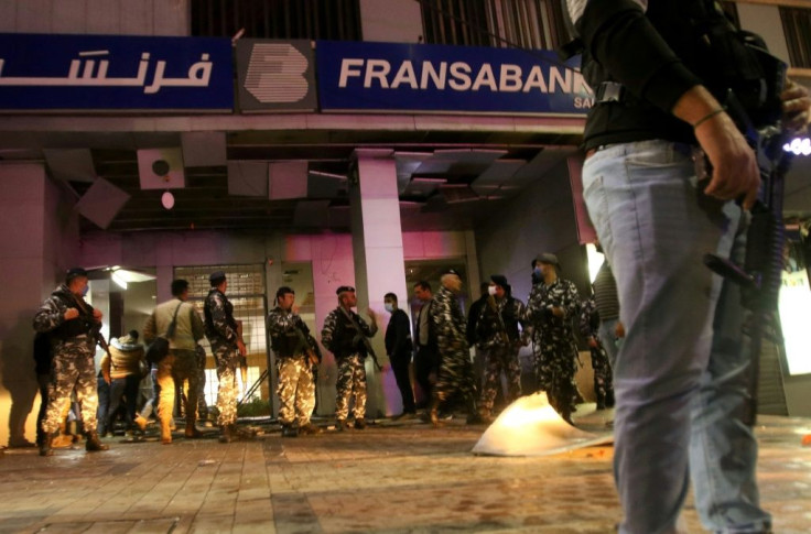 Lebanese security forces inspect the entrance to a Fransabank branch in the southern city of Sidon on April 25 after unknown assailants targeted it with an explosive device