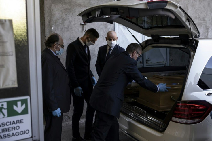 Palmero funeral home employees put the coffin of a COVID-19 victim into a hearse at the morgue of  Saluzzo hospital in northwestern Italy ahead of a funeral with very limited family contact.