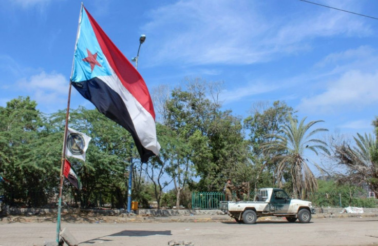 Fighters with Yemen's Southern Transitional Council drive past a separatist flag -- the flag of the former nation of South Yemen -- in the city of Aden