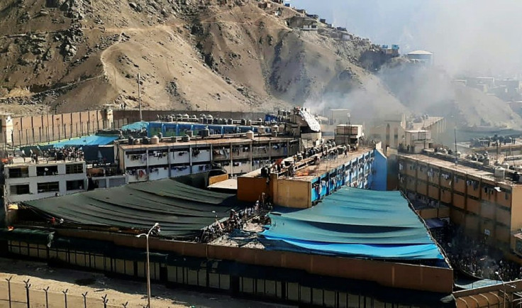 Smoke rises from the Castro Castro prison as inmates torched matresses in protest