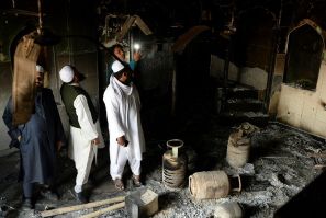 Muslim men check the interior of a partially burnt mosque on March 1, 2020 after communal riots in New Delhi