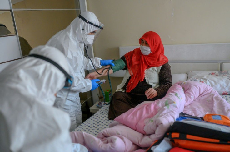 Health workers help a woman who tested positive for the novel coronavirus COVID-19,  at Bagcilar in Istanbul