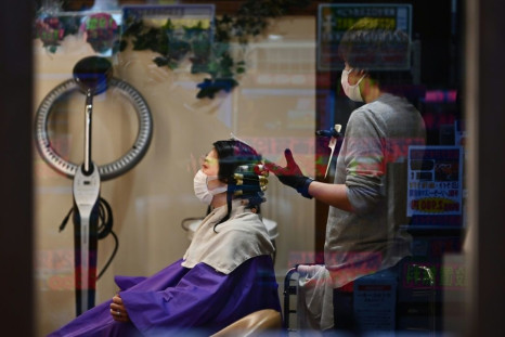People wearing face masks visit a hair salon in Tokyo