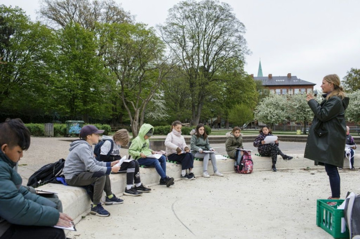 Teacher Marie Kaas-Larsen speaks with her pupils of the Norrebro Park primary school outside in a nearby park in Copenhagen, Denmark