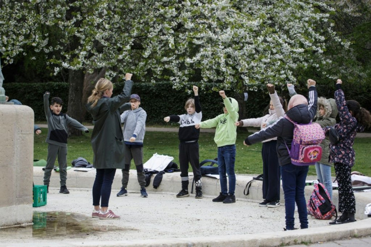 School's back in -- but outside -- Teacher Marie Kaas-Larsen and her pupils warm up for outdoor lessons in a park near their Copenhagen school