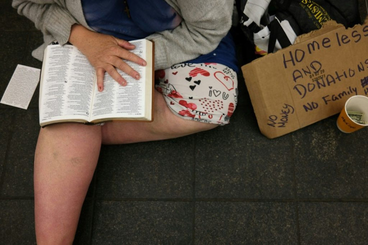 A homeless woman sits in a subway tunnel in New York on April 13