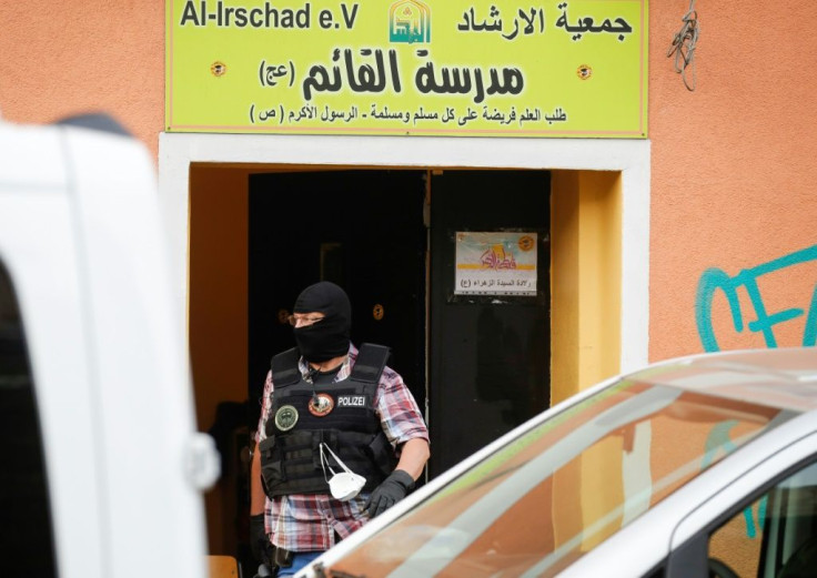 A police officer walks out of Al-Irschad Mosque during a raid in Berlin, as dozens of police and special forces stormed mosques and associations linked to Hezbollah in Bremen, Berlin, Dortmund and Muenster early Thursday.