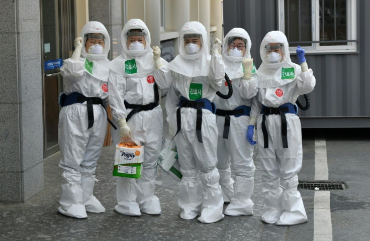 South Korean nurses wearing protective gear pose as they start their shift to care for patients infected with the COVID-19 coronavirus at a hospital in Daegu -- the country reported zero new infections for the first time