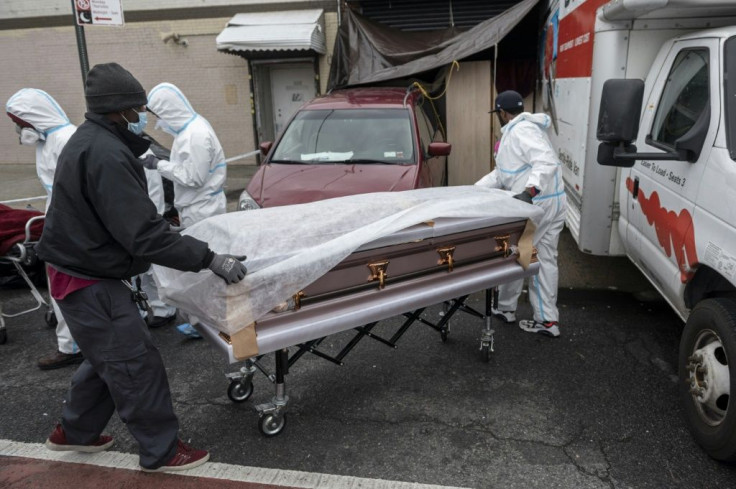 People wearing  hazmat suits and masks transport a casket into a funeral home in Brooklyn on April 30, 2020 where dozens of decomposing bodies were found in trucks