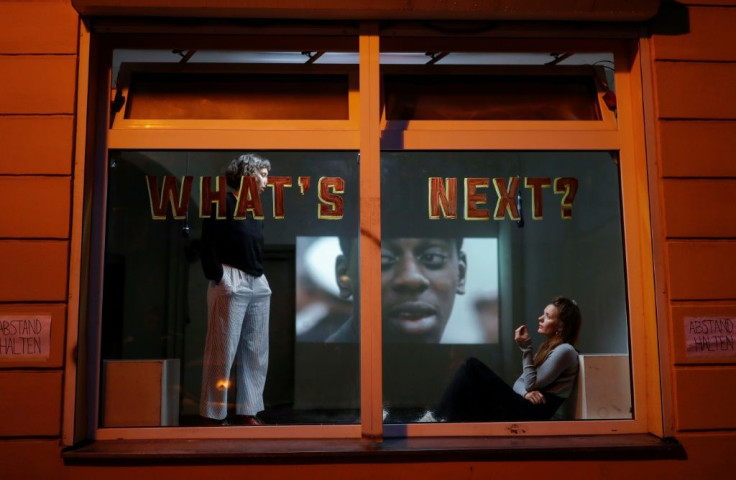 Performance artists put on a show in a window of a house in the Liebig Steet in Berlin's Friedrichshain district