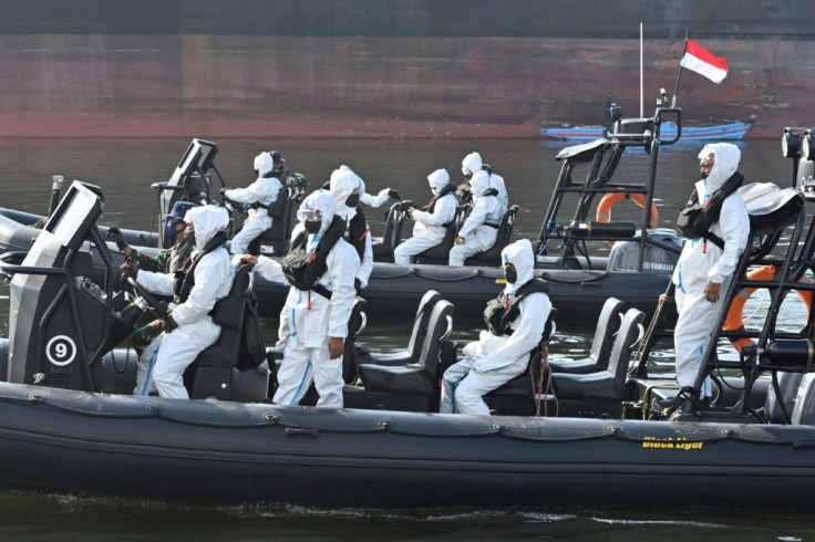 Elite Indonesian navy frogmen wearing protective gear keep watch at a port in Jakarta as over 300 Indonesian crewmembers of the Explorer Dream cruise ship are brought ashore for testing and quarantine amid the COVID-19 pandemic