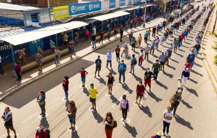 Shoppers keep social distancing rules as the queue up outside a market in the Peruvian city of Piura