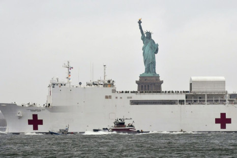The hospital ship USNS Comfort passes the Statue of Liberty as its departs New York City