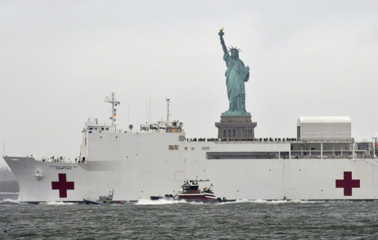 The hospital ship USNS Comfort passes the Statue of Liberty as its departs New York City