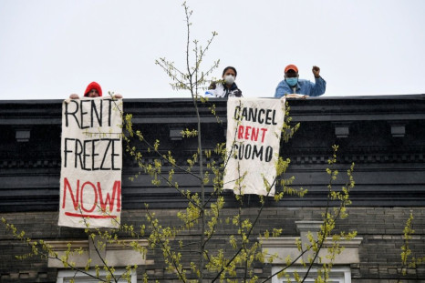 Building tenants hang signs from their roof in the Crown Heights neighborhood during a rent strike that organizers said thousands participated in