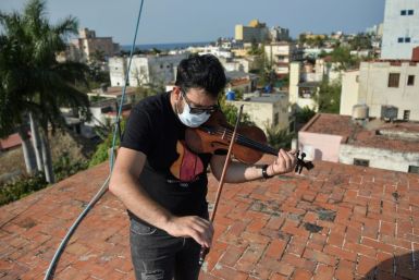 Cuban violinist William Roblejo rehearses on the rooftop of his house in Havana