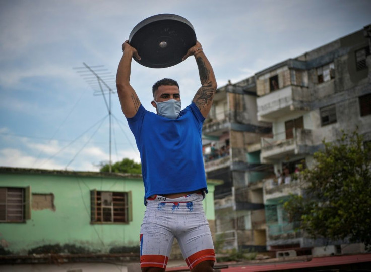 Greco-Roman wrestler Daniel Gregorich trains with weights on a Havana rooftop