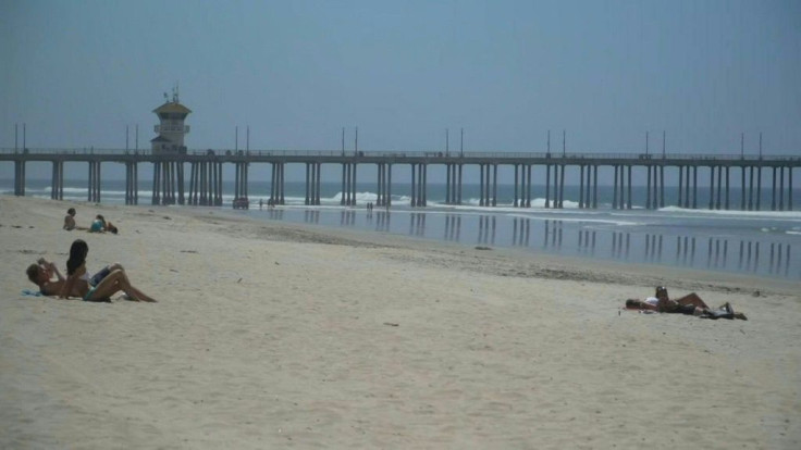 Dozens of people head to the shore in Huntington Beach near Los Angeles even though the beach is officially closed amid the coronavirus pandemic