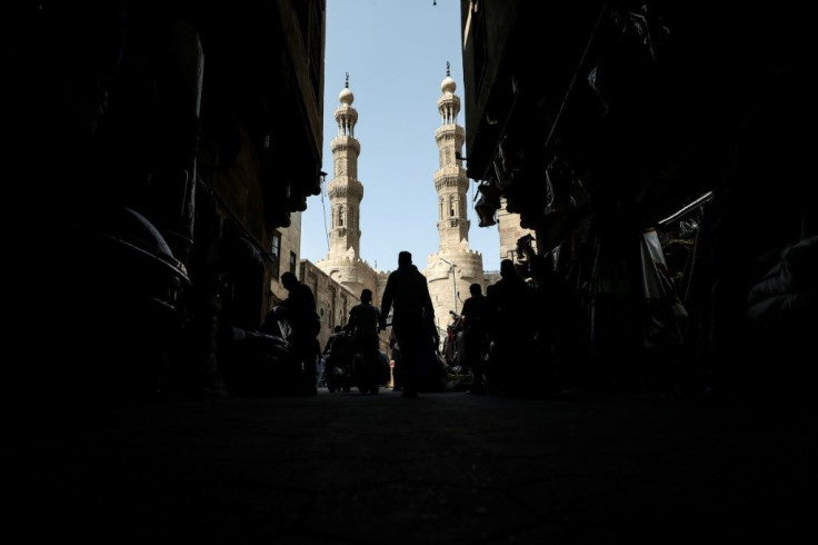 People shop on roofed Khayamiya Street in the old city of the Egyptian capital Cairo; A young Egyptian filmmaker imprisoned for directing a music video critical of President Abdel Fattah al-Sisi has died in a Cairo jail