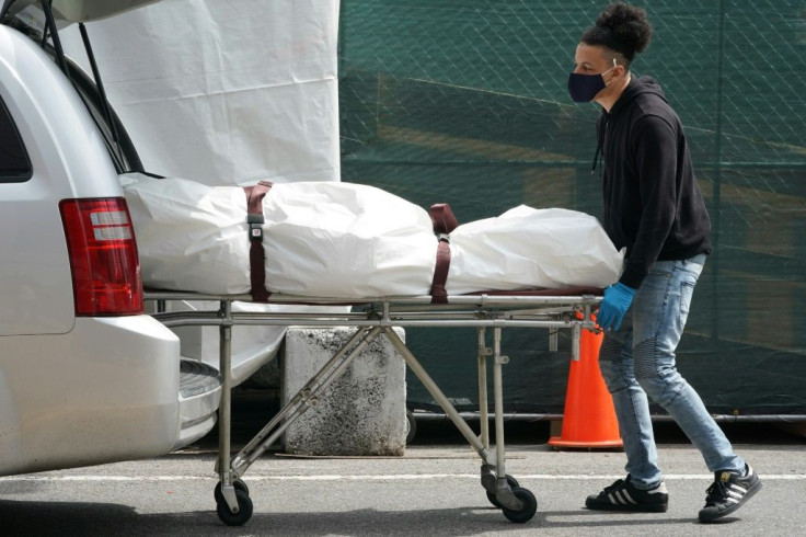 A body is moved from a refrigeration truck serving as a temporary morgue to a vehicle at the Brooklyn Hospital Center in April 2020