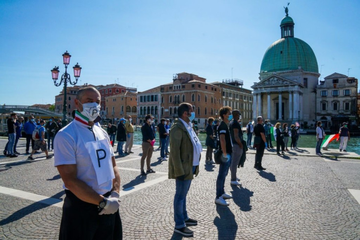 The new data came as Italy eased nine weeks of confinement, though shopkeepers such as these protesters in Venice will be unable to reopen for another two weeks