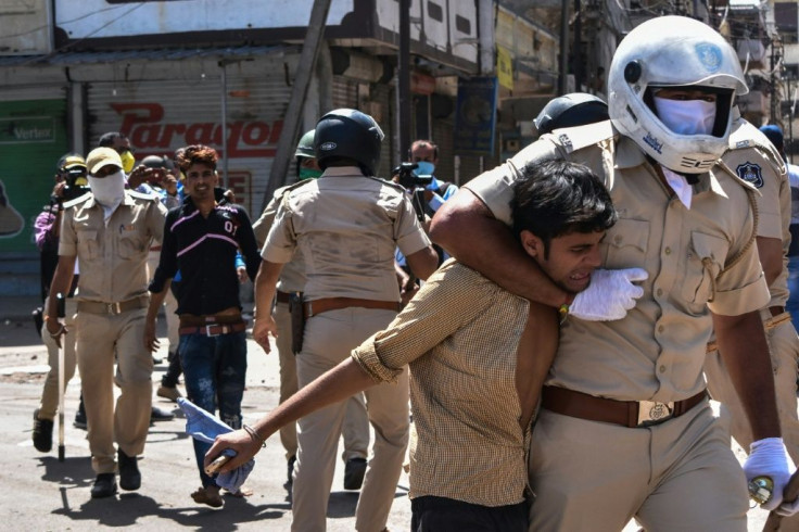 Gujarat police detain stranded migrant workers during a protest demanding they be allowed to return to their homes during India's nationwide lockdown