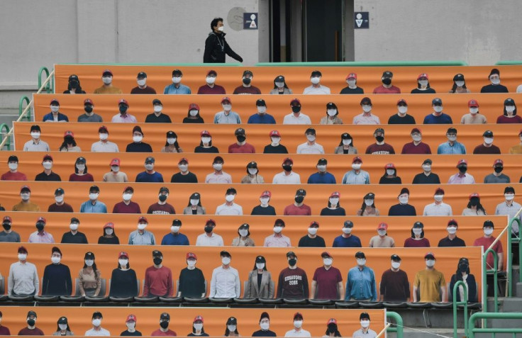 A man walks past banners depicting spectators in the stands prior to South Korea's new baseball season opening in Incheon
