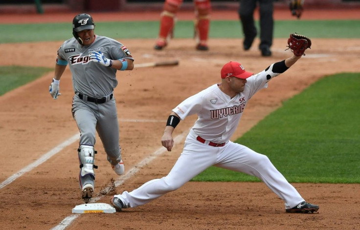 SK Wyverns infielder Jamie Romak (R) forces out Hanwha Eagles' Ha Ju-suk (L) at first base in the second inning during the opening game for South Korea's new baseball season at Munhak Baseball Stadium in Incheon