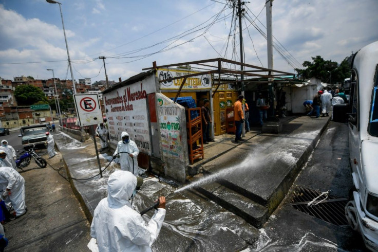 Municipal workers wearing protective equipment clean against the coronavirus in Caracas