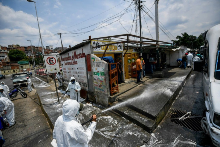 Municipal workers wearing protective equipment clean against the coronavirus in Caracas