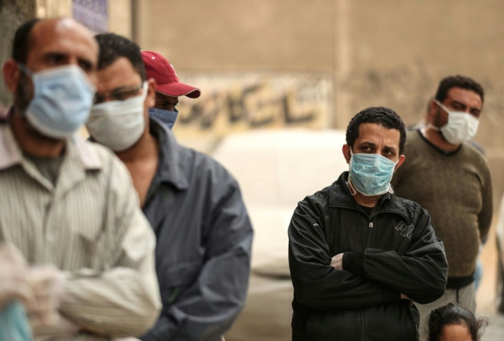 Men wait outside a centre of the non-governmental Egyptian Food Bank to receive cartons with foodstuffs in April