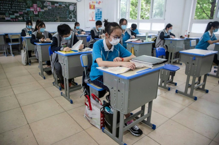 School rules: desks are placed a metre apart and class sizes have been reduced as Chinese senior school children get back in front of the chalk board